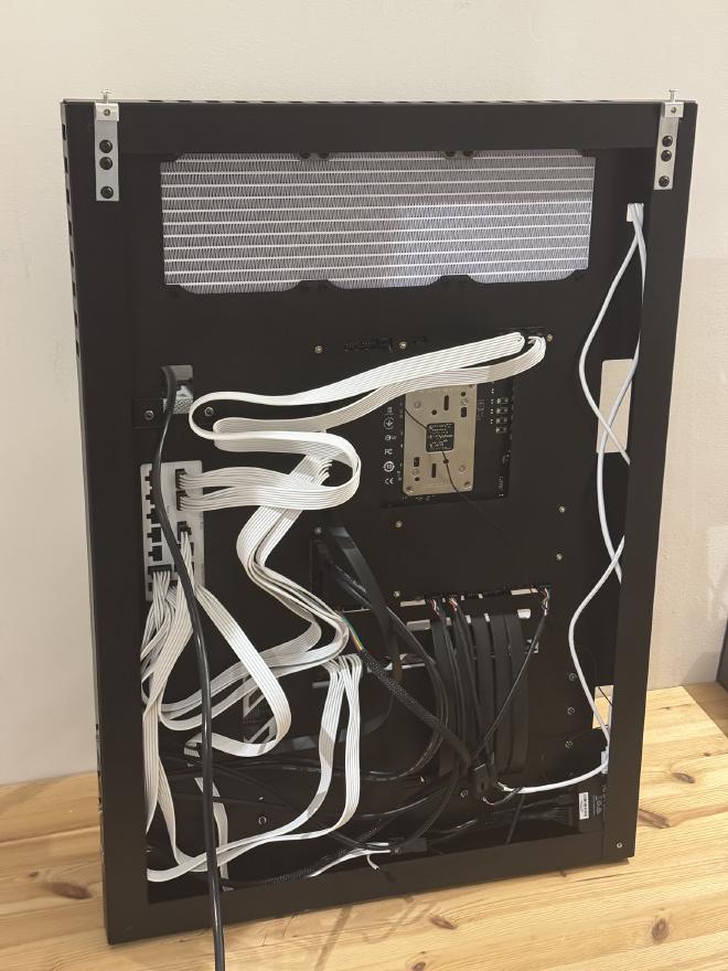 Photograph of the back of the &ldquo;case&rdquo;, it shows all the cables going up and down (mostly) and some horizontally